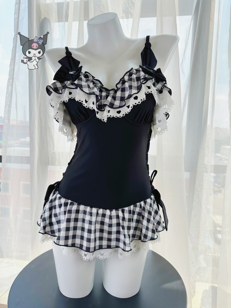 Mannequin wearing a black and white checkered dress with ruffled details against a light curtain background.