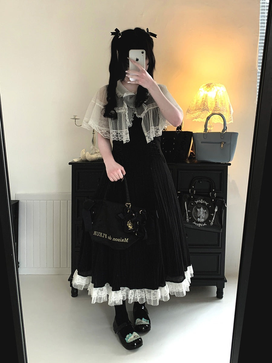 Person wearing a black and white outfit with a matching bag, standing in front of a mirror.