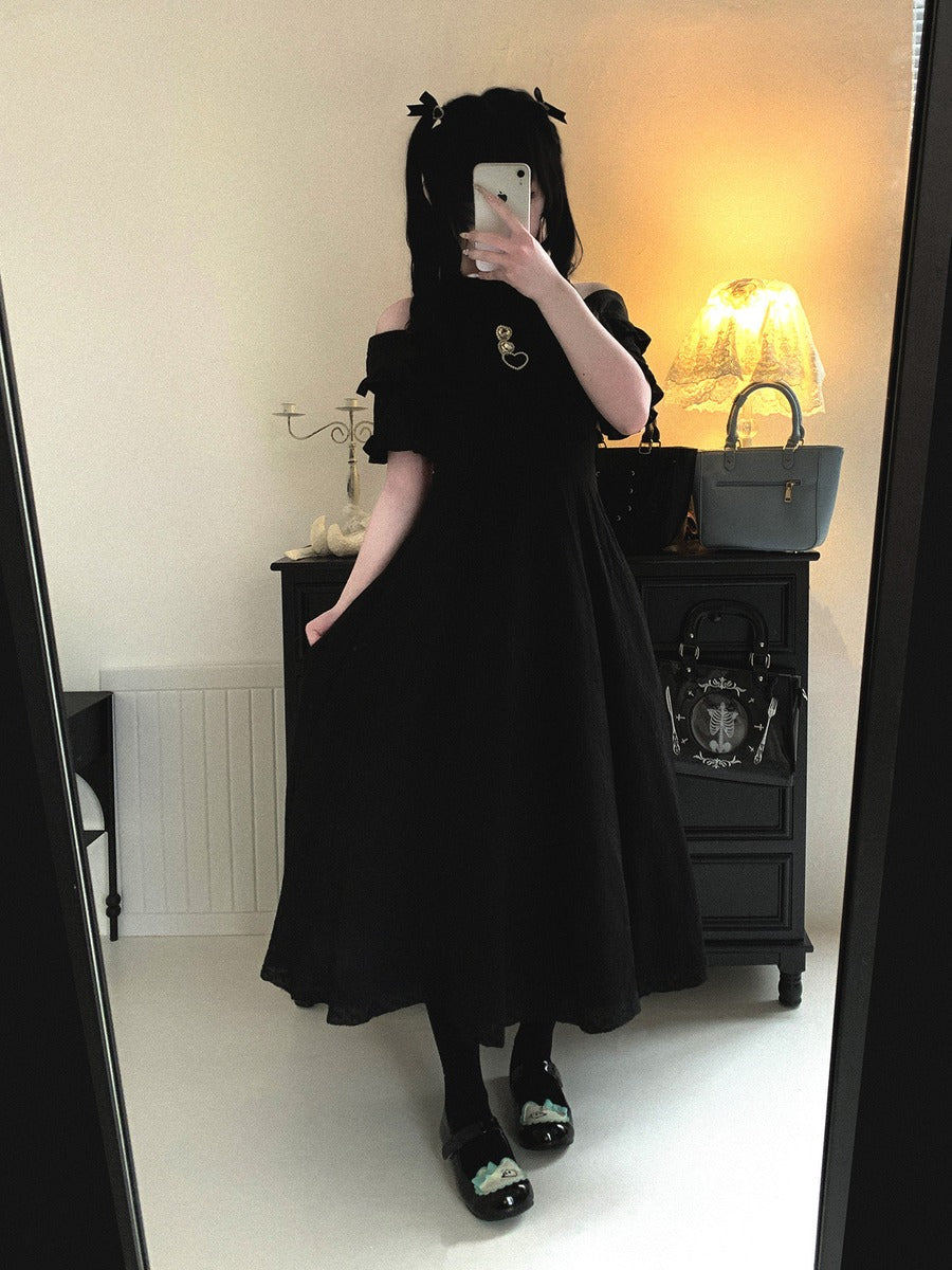 Person wearing a black dress in a room with a mirror reflection.