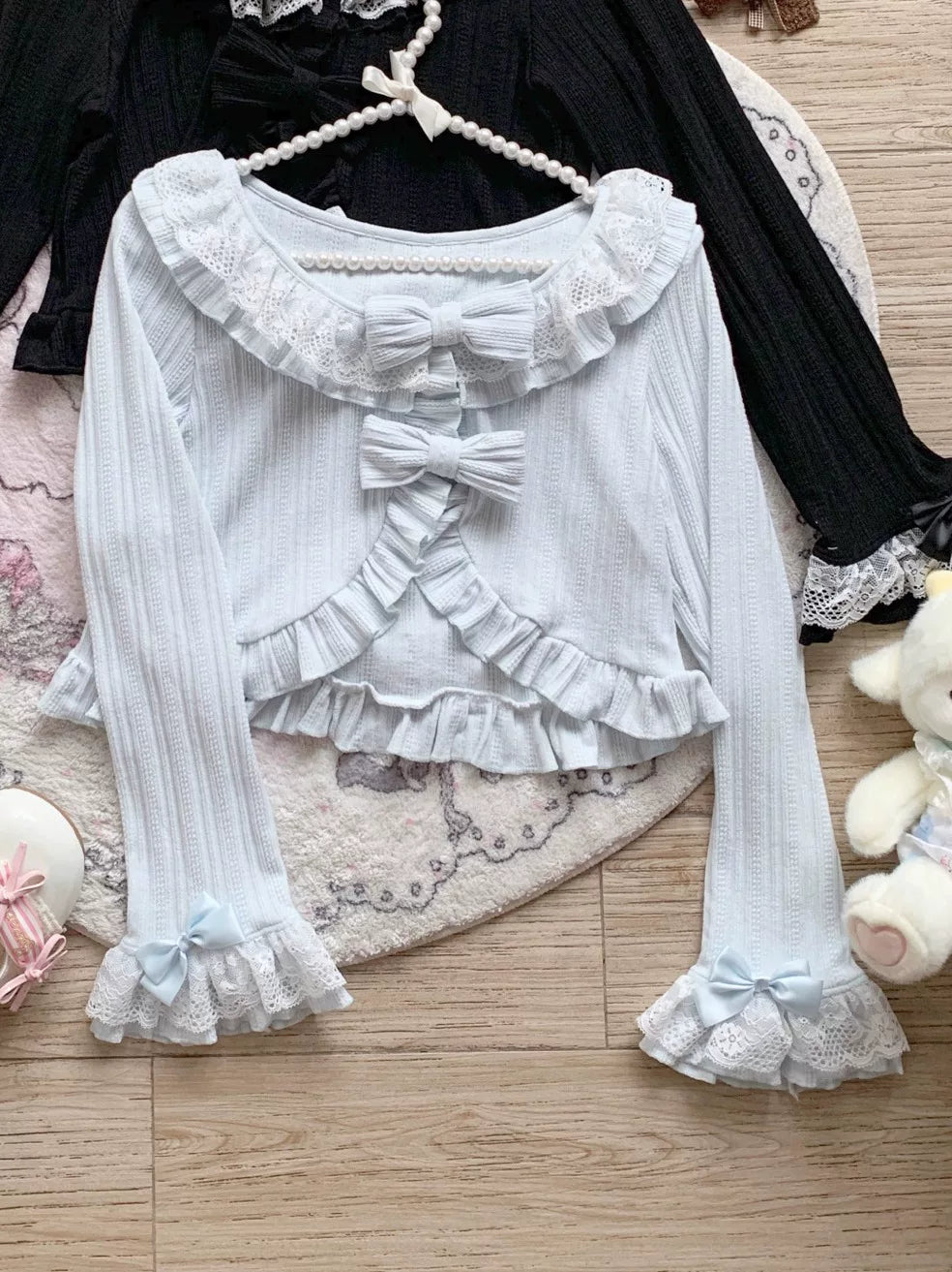 White lace blouse with ruffled details on a wooden floor.