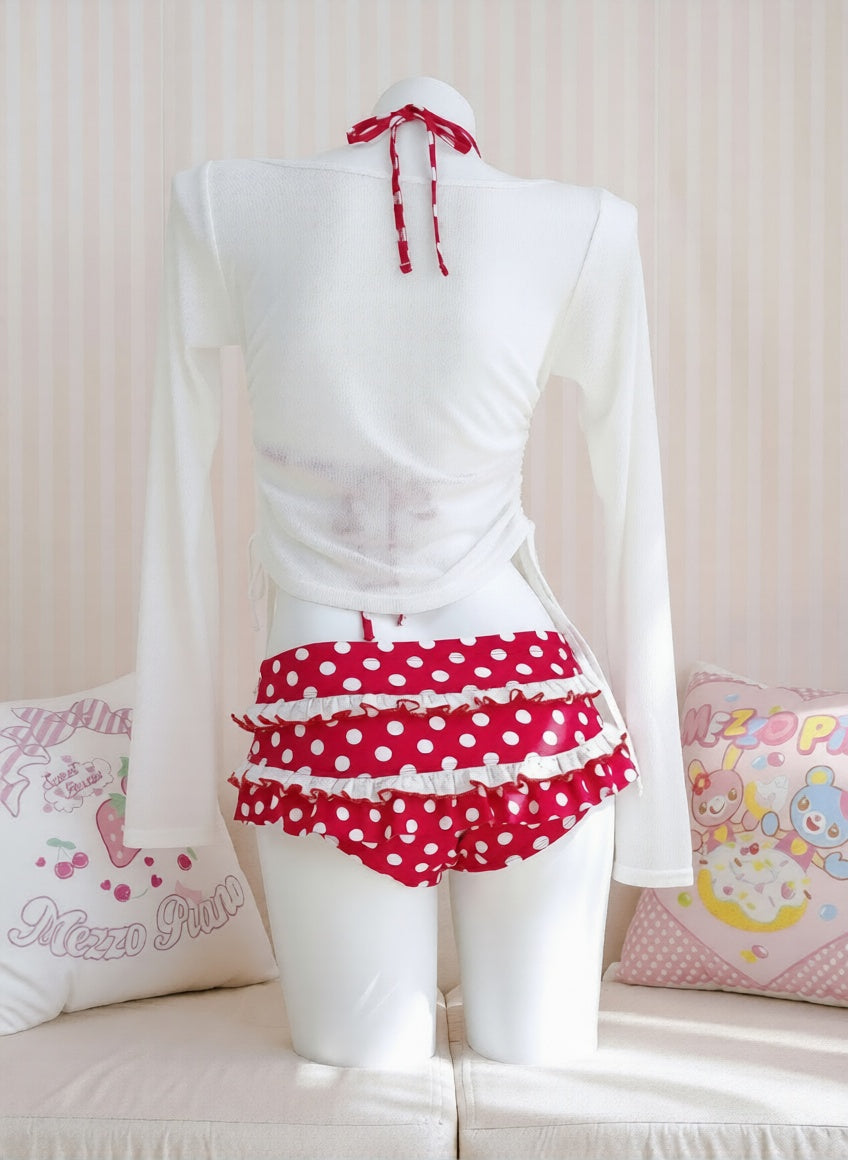 Mannequin wearing a white blouse with red polka dot shorts on a light background