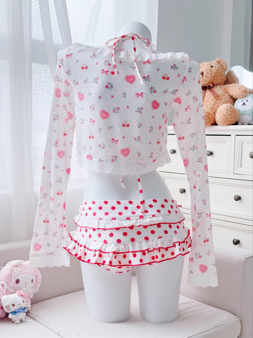 Mannequin wearing a white blouse with red floral patterns and a red polka dot skirt in a room setting.