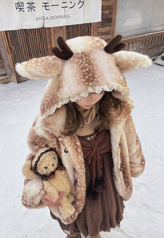 Person wearing a cute lolita style deer-themed hoodie with a teddy bear in a snowy setting