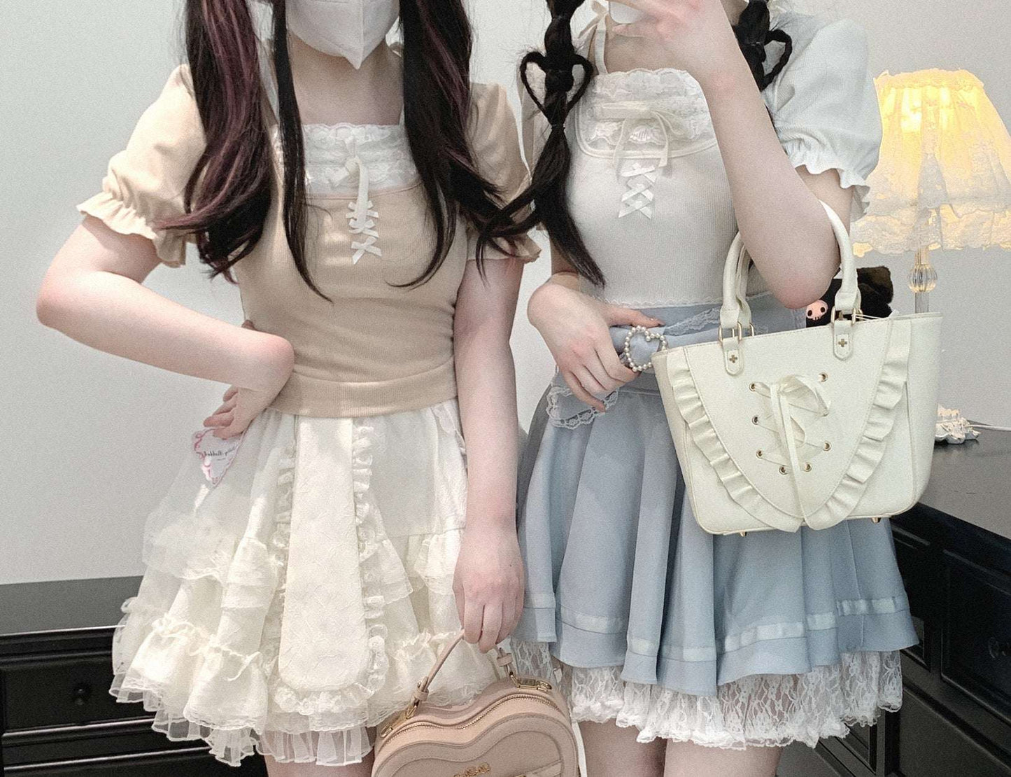 Two people in pastel outfits with ruffled skirts and matching handbags.