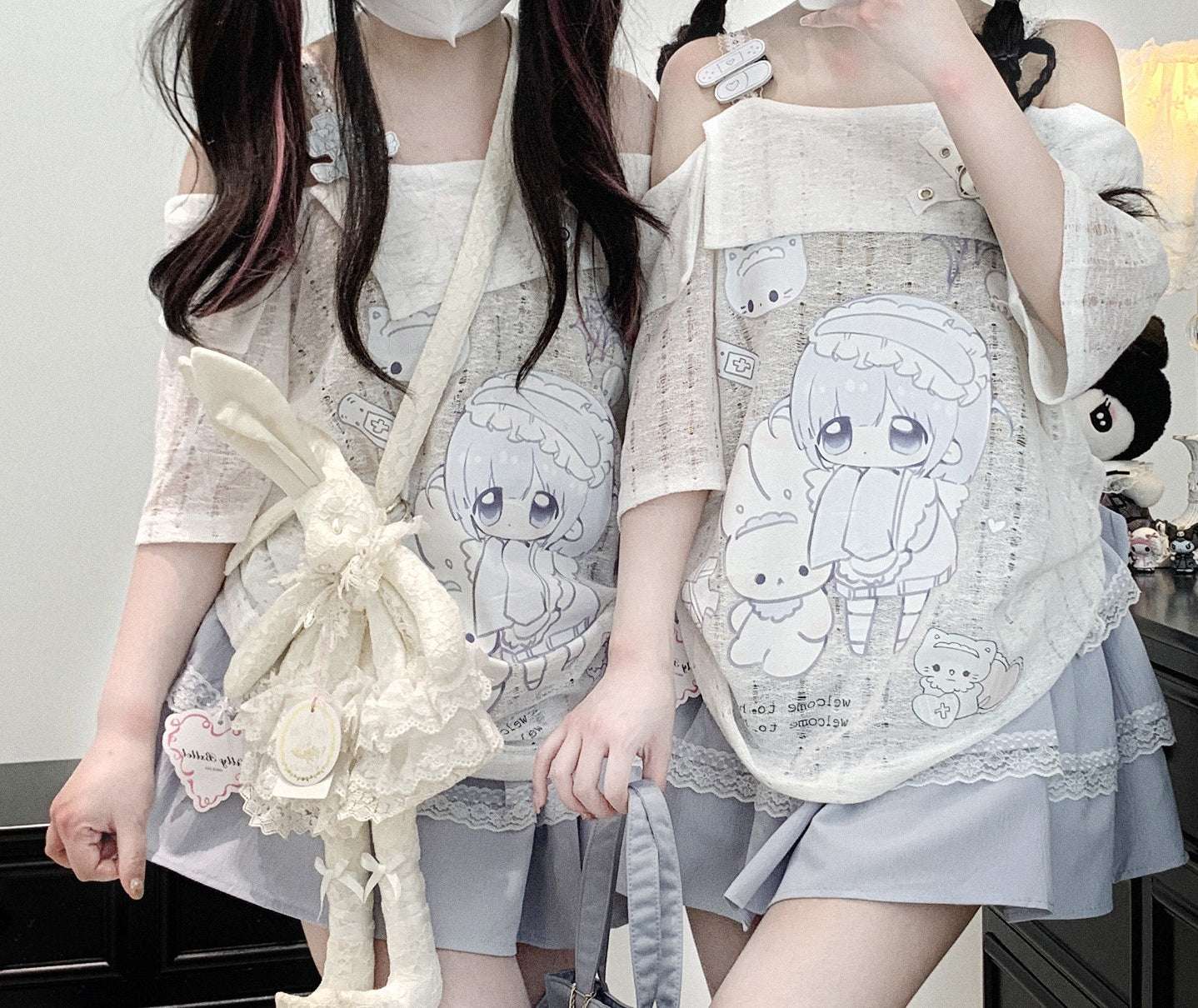 Two people wearing short-sleeve white top with cartoon designs in a room setting.