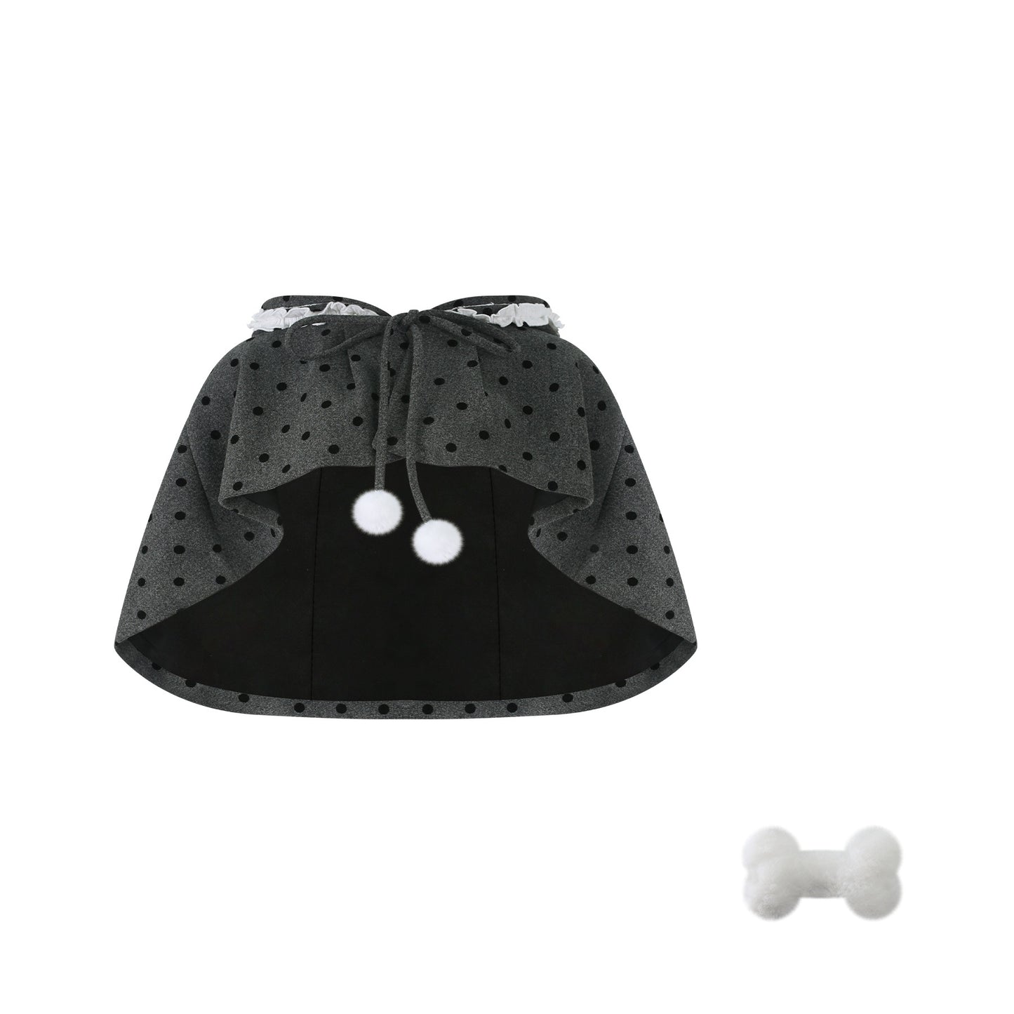 Black cape with white polka dots and a bone-shaped toy on a white background