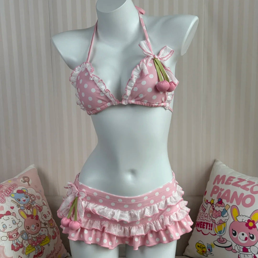 Pink polka dot bikini set on a mannequin with decorative pillows in the background