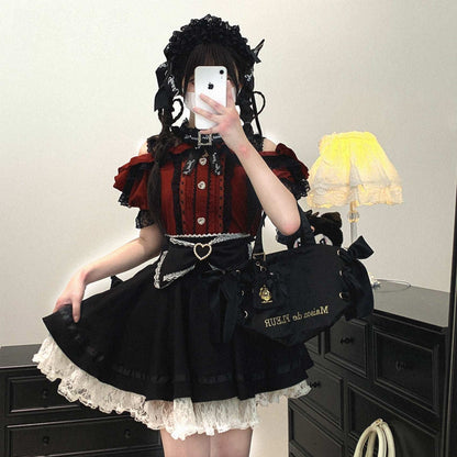 Person wearing a black and red outfit with a matching bag, standing in a room.