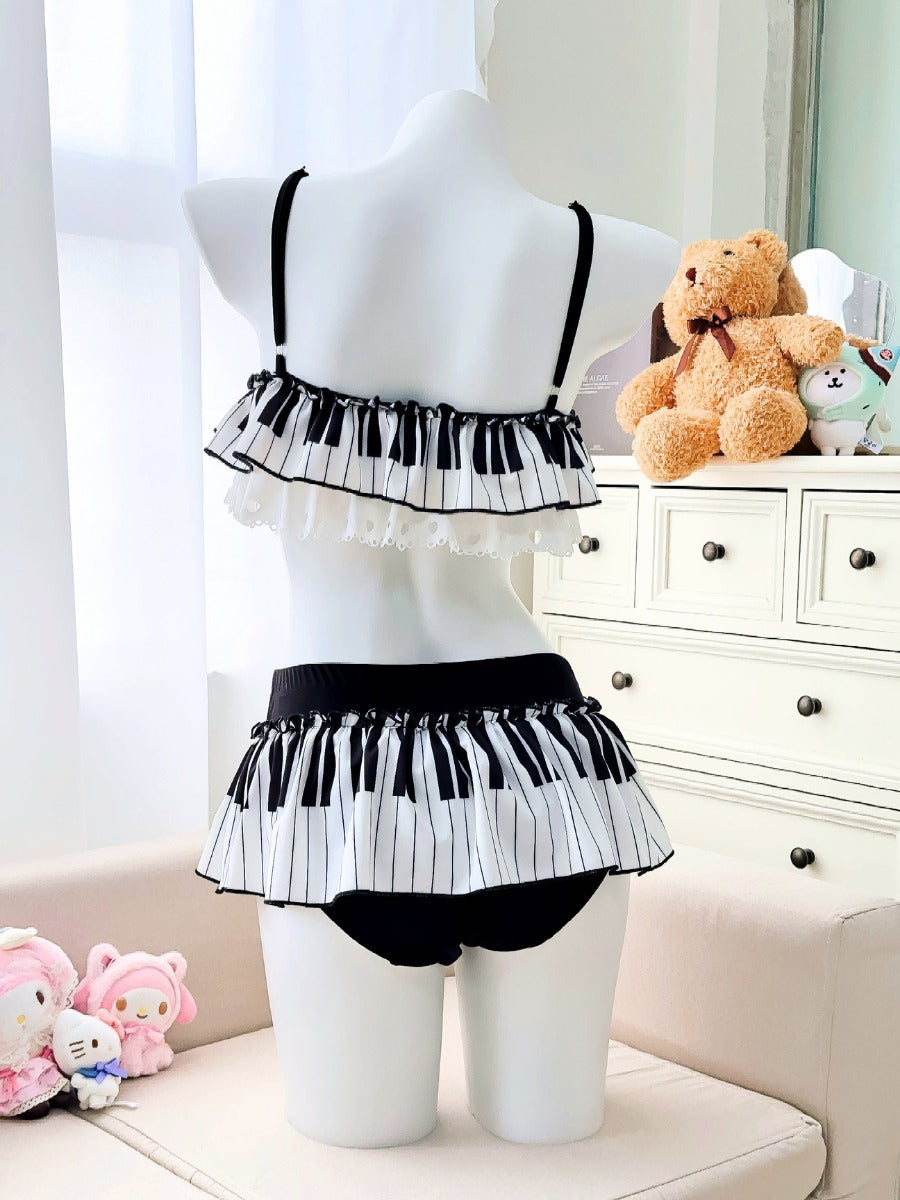 Mannequin wearing a black and white piano-themed lingerie set with teddy bears in the background.