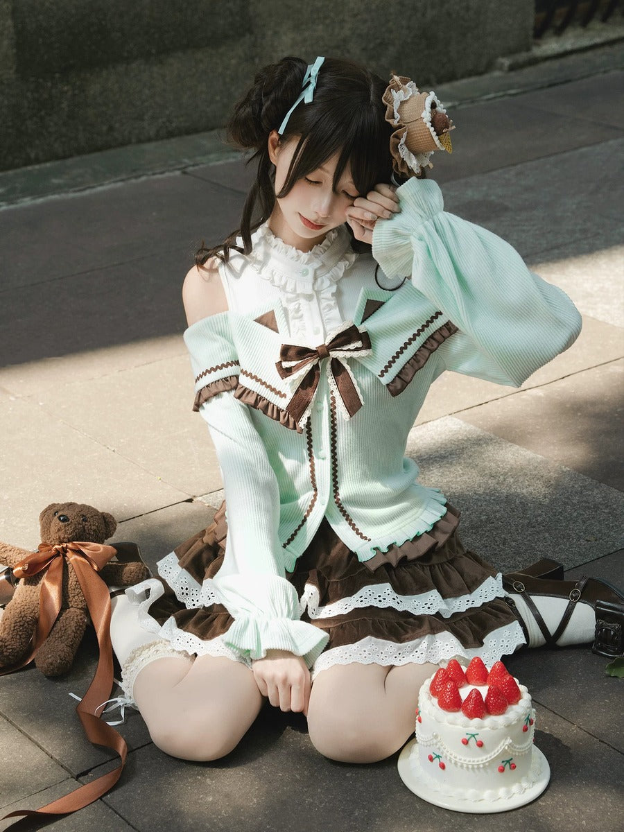Person in a detailed outfit with a teddy bear and cake on a stone floor