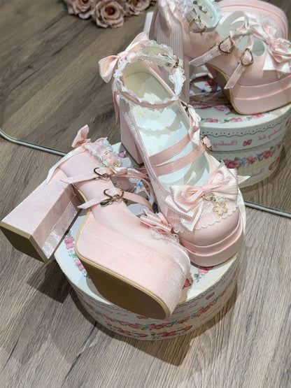 Pair of pink high-heeled shoes with decorative elements on a wooden surface.