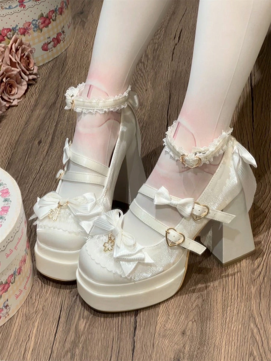 White platform heels with decorative bows on a wooden floor.