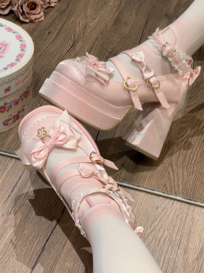 Pink high-heeled shoes with decorative bows on a wooden floor.