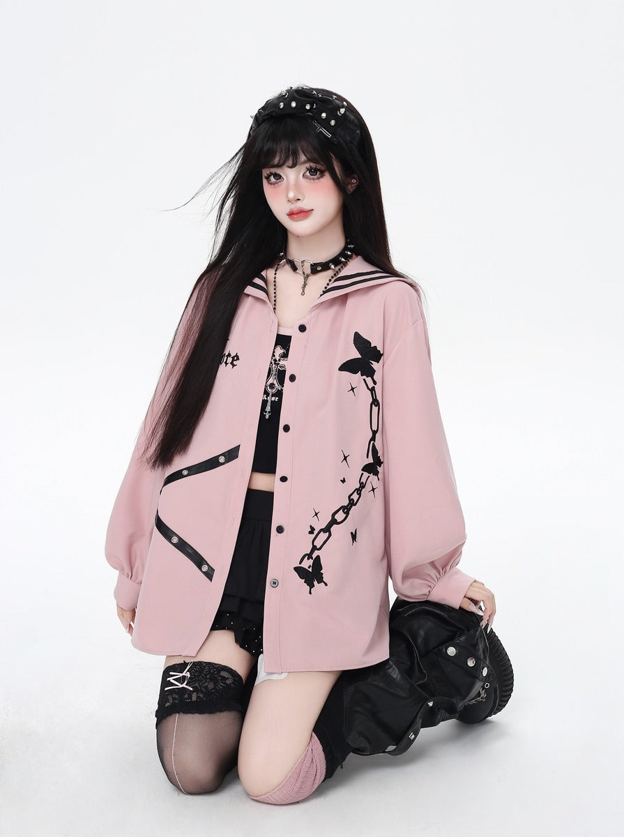 Person wearing a pink oversized jacket with black designs on a white background