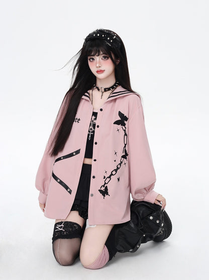 Person wearing a pink oversized jacket with black designs on a white background