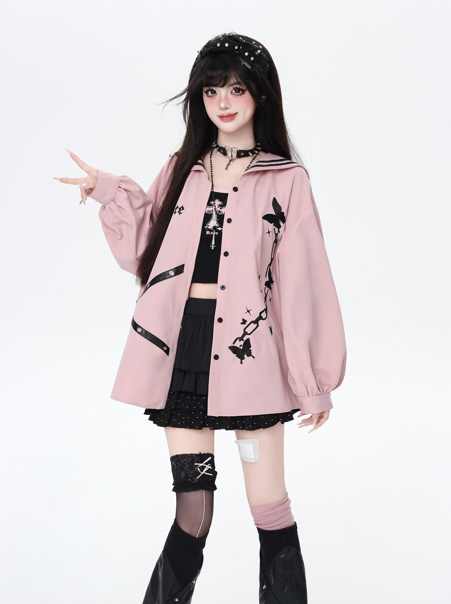 Person wearing a pink jacket with black floral designs on a white background