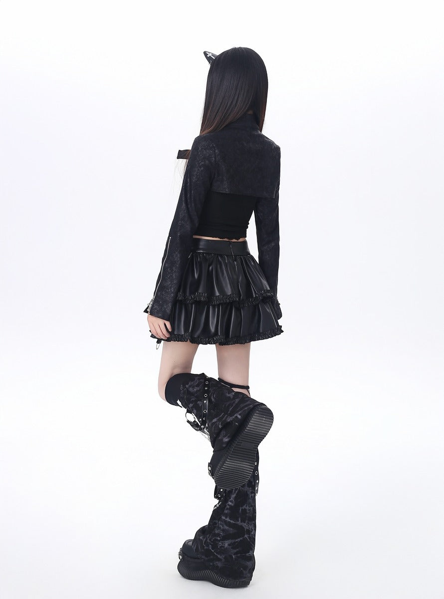 Person wearing a black outfit with a hood and skirt on a white background