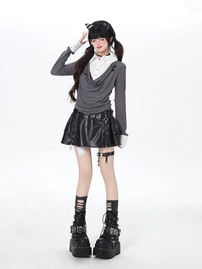 Person wearing a gothic outfit with a gray sweater, black leather skirt, and platform boots on a white background.