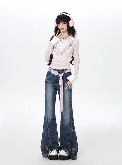 Person wearing a pink sweater and blue jeans with a white background