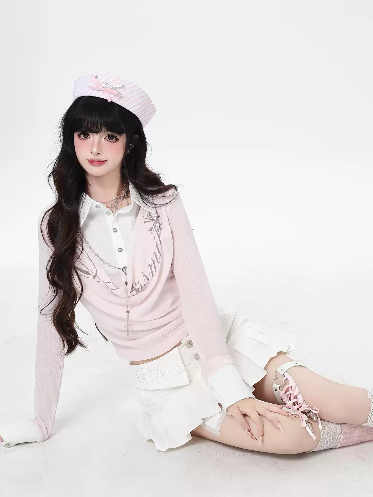 Person wearing a pink outfit with a white hat on a white background
