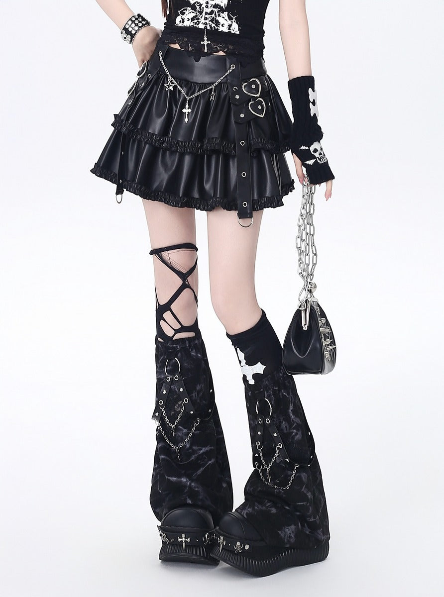 Person wearing a black gothic outfit with high boots, skirt, and accessories on a white background