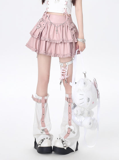 Person wearing a pink skirt, white stockings, and high-heeled shoes with decorative straps on a white background