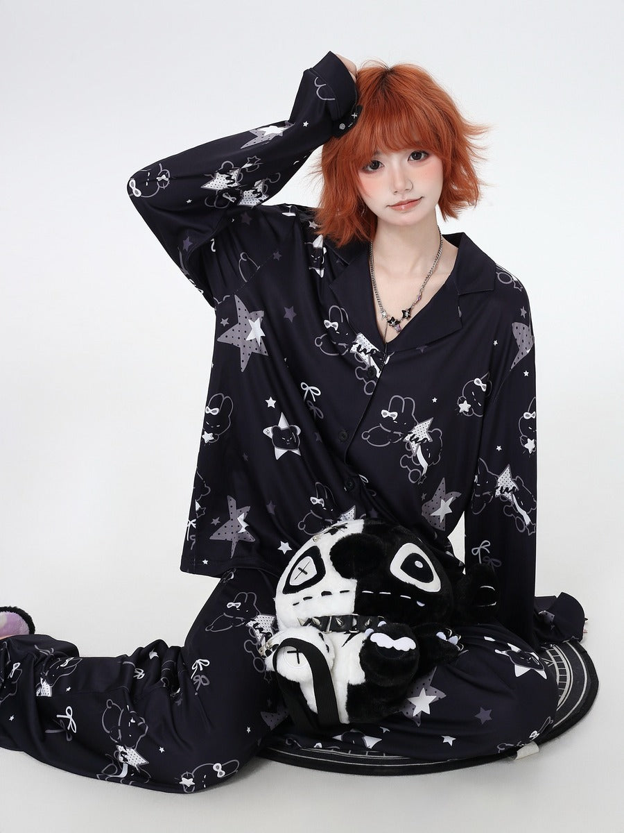 Person wearing a black cozy pajamas with white patterns on a white background
