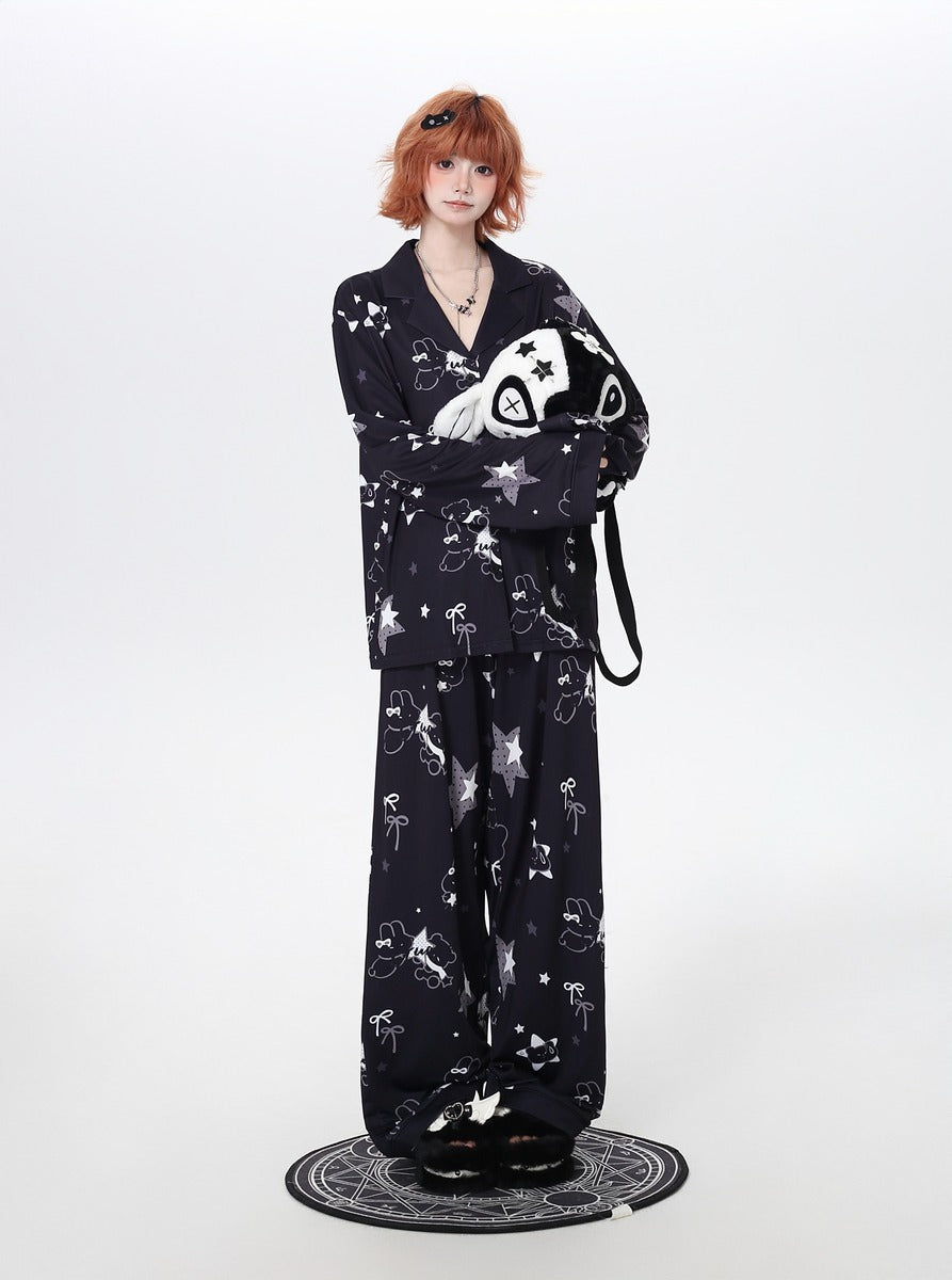 Person wearing a black cozy pajamas with white patterns on a white background