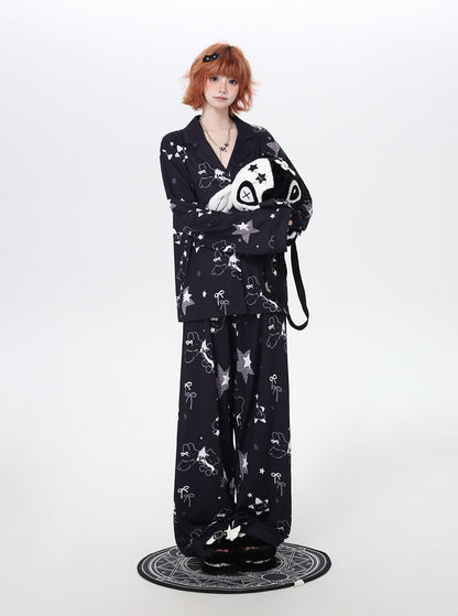 Person wearing a black cozy pajamas with white patterns on a white background