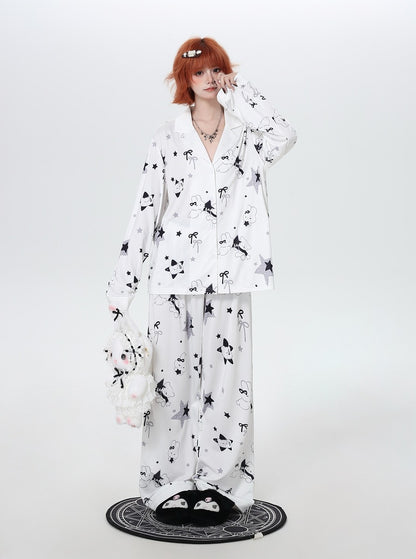 Person wearing a white cozy pajamas with black floral patterns on a white background