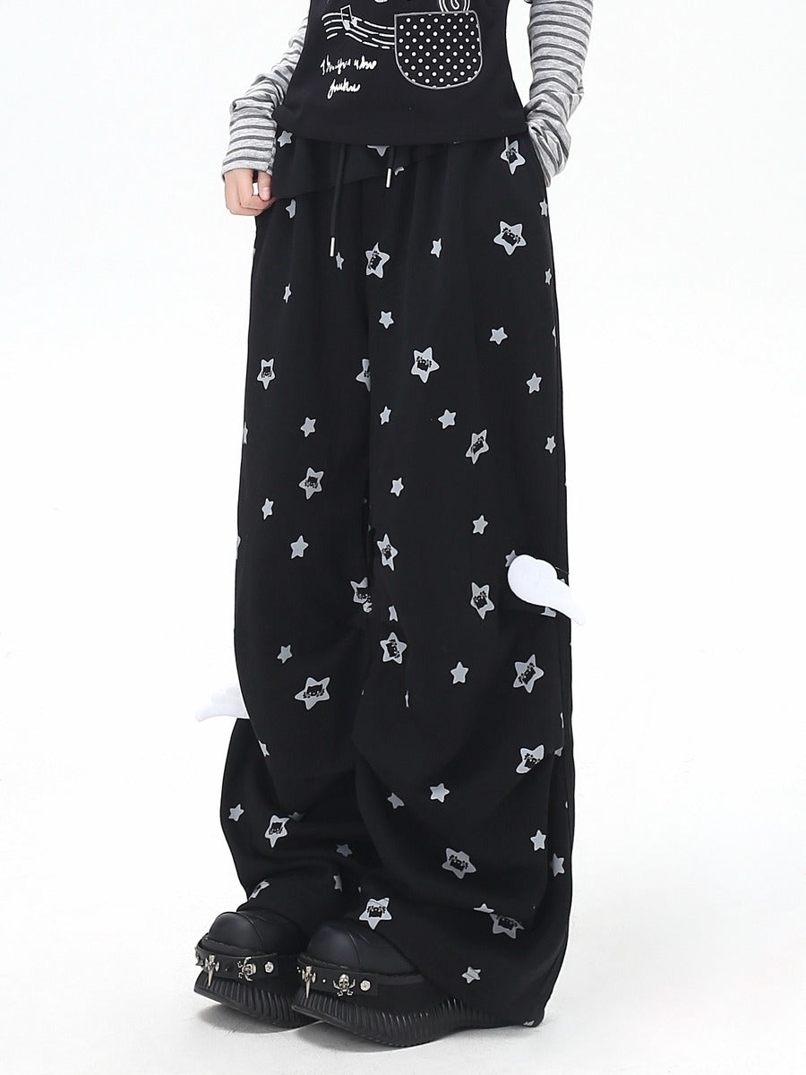 Black wide-leg pants with star patterns worn by a person on a white background