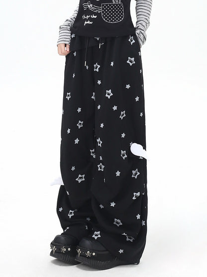 Black wide-leg pants with star patterns worn by a person on a white background