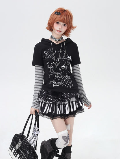 Person wearing a black hoodie with keyboard design, black skirt, and holding a black bag with keyboard design on a white background.