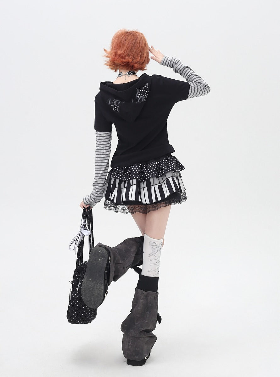 Person wearing a black outfit with a keyboard skirt on a white background