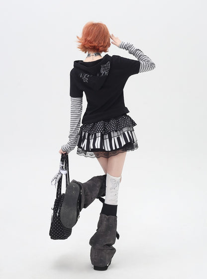 Person wearing a black outfit with a keyboard skirt on a white background