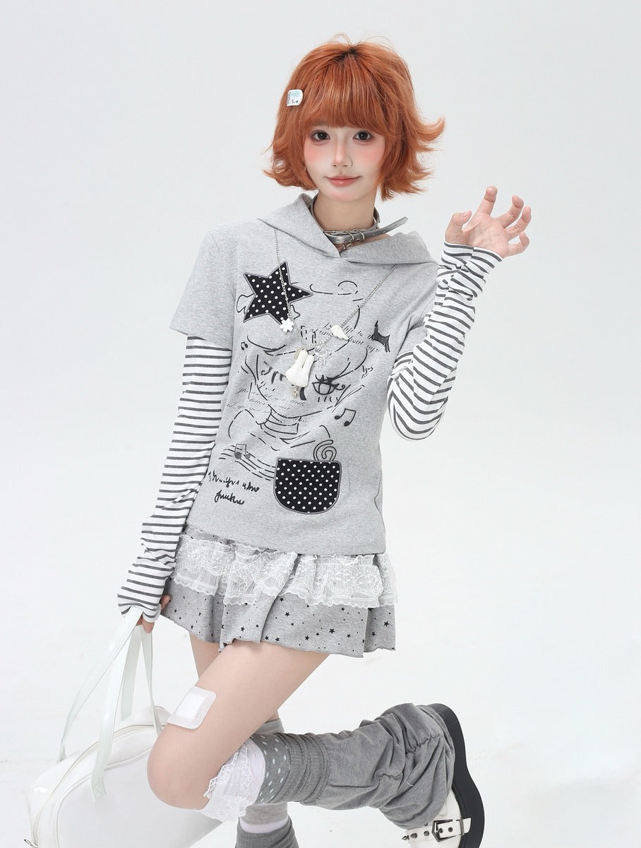 Person wearing a gray hoodie with cartoon design and striped sleeves on a white background