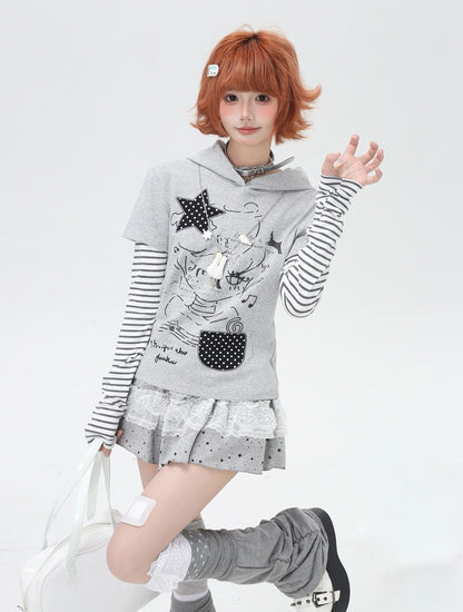 Person wearing a gray hoodie with cartoon design and striped sleeves on a white background