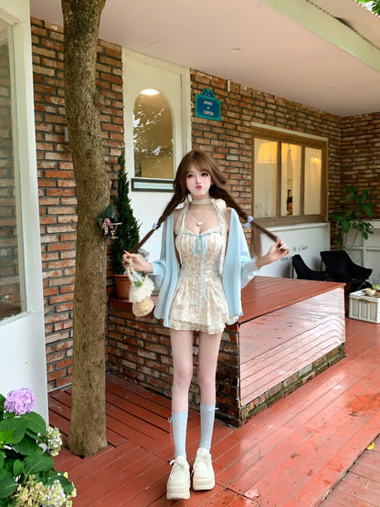 Woman in a light outfit standing on a wooden deck with a brick wall and plants in the background