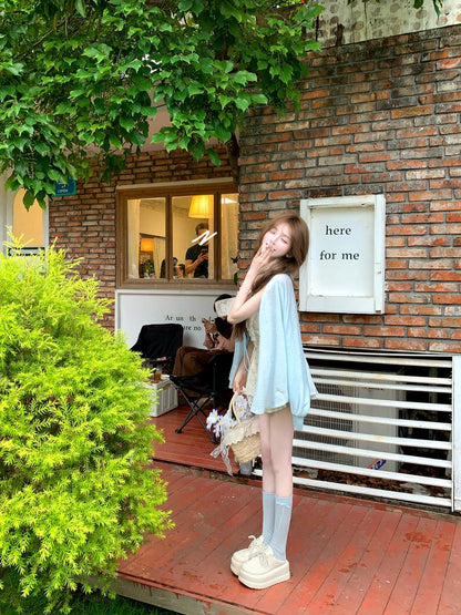 Woman standing in front of a brick wall with greenery