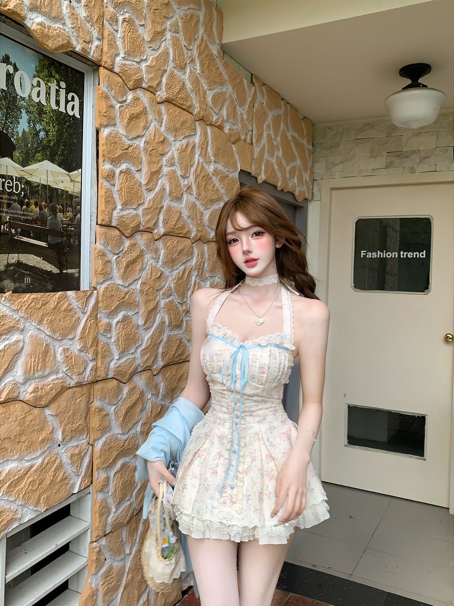 Woman in a floral dress standing in front of a building with a stone facade.