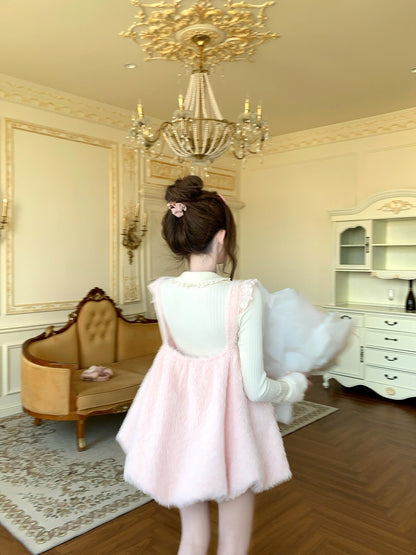 Person in a pink dress standing in an elegant room with a chandelier and furniture.
