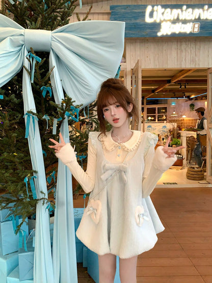 Woman in a white dress posing in front of a decorated Christmas tree and festive decor.