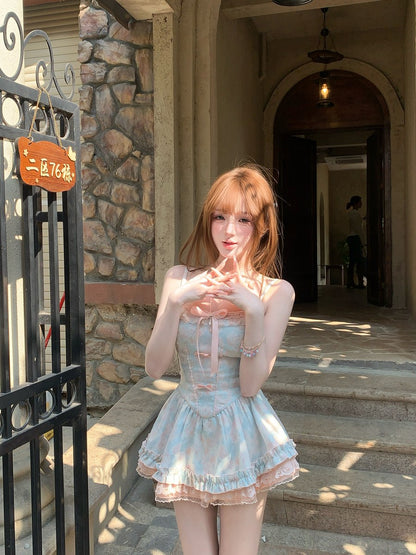 Woman in a light blue dress standing on steps outside a building.