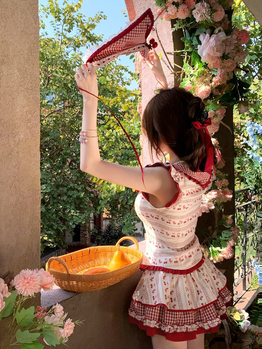 Woman in a white and red dress with floral decorations, holding a bow and arrow.