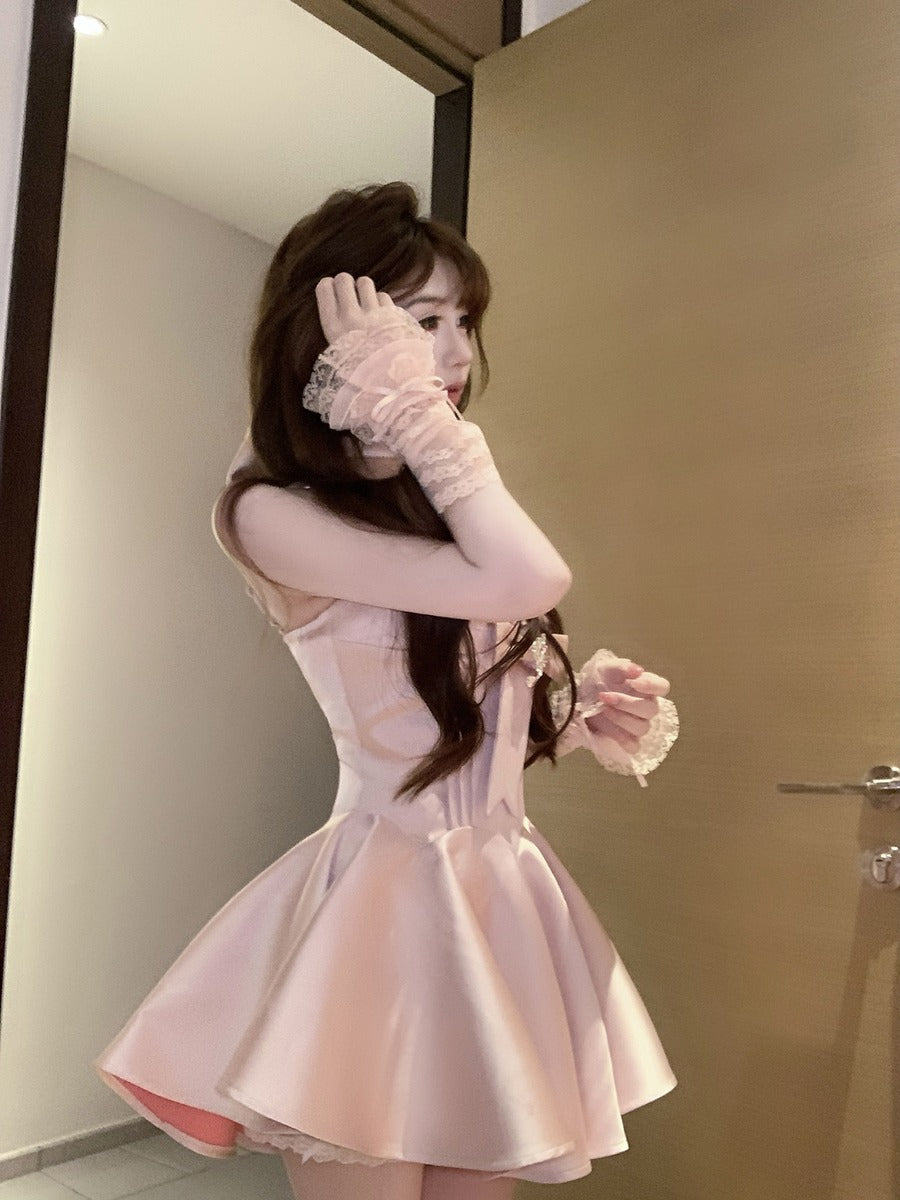 Woman wearing a pink dress and gloves in a room with a mirror.