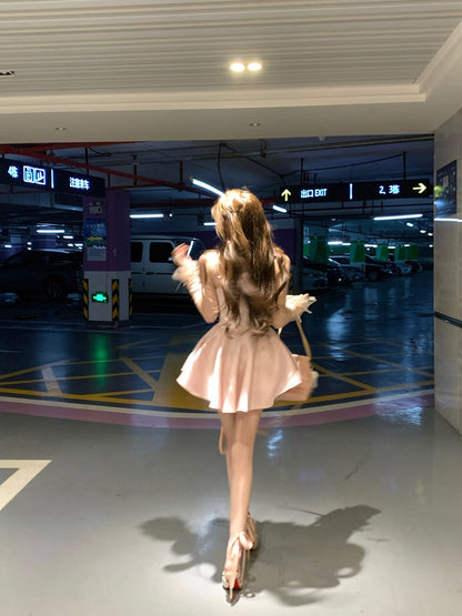 Woman in a pink dress standing in a parking garage.