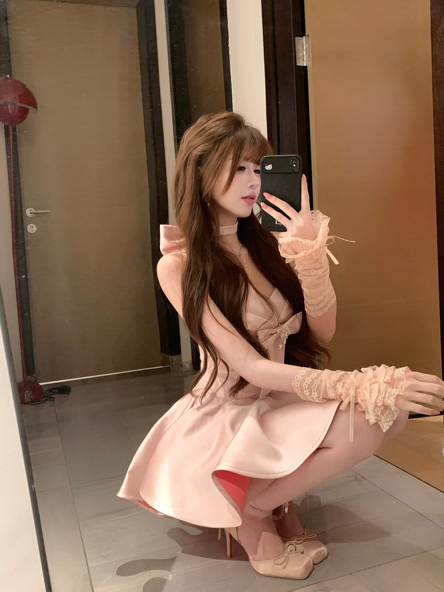 Woman in a pink dress taking a mirror selfie in an indoor setting.