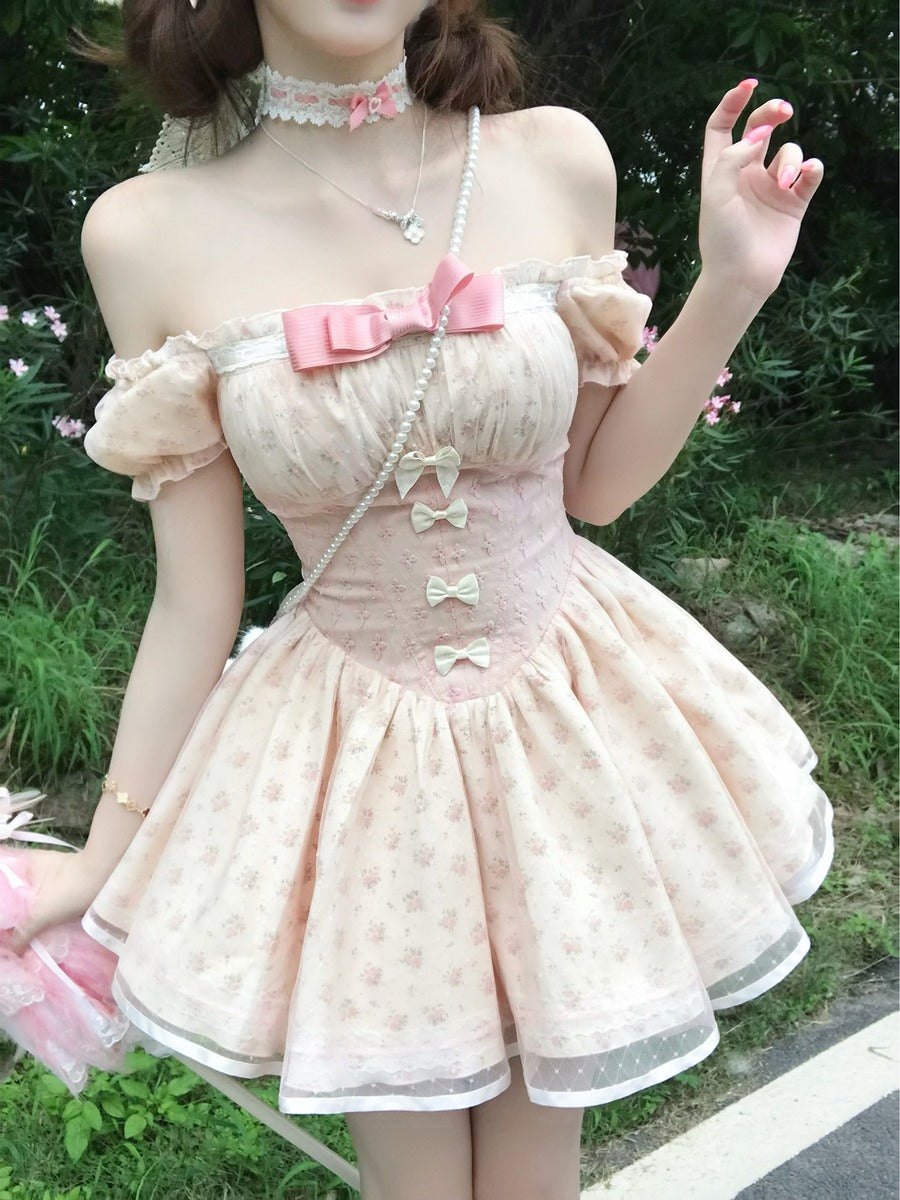Person wearing a pastel-colored dress with bow details outdoors.