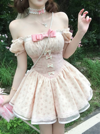Person wearing a pastel-colored dress with bow details outdoors.