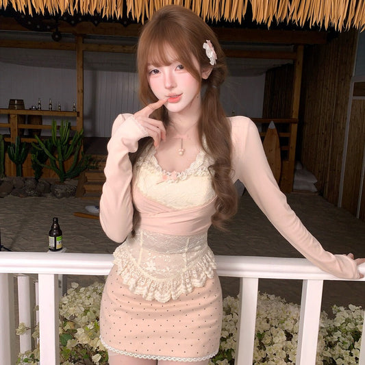 Woman in a light pink dress standing in a decorated indoor setting with plants and a bottle.